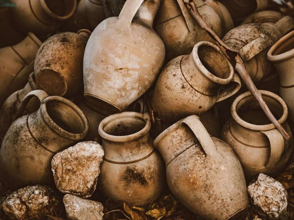 Ânforas e potes de barro antigos empilhados, com a superfície gasta pelo tempo